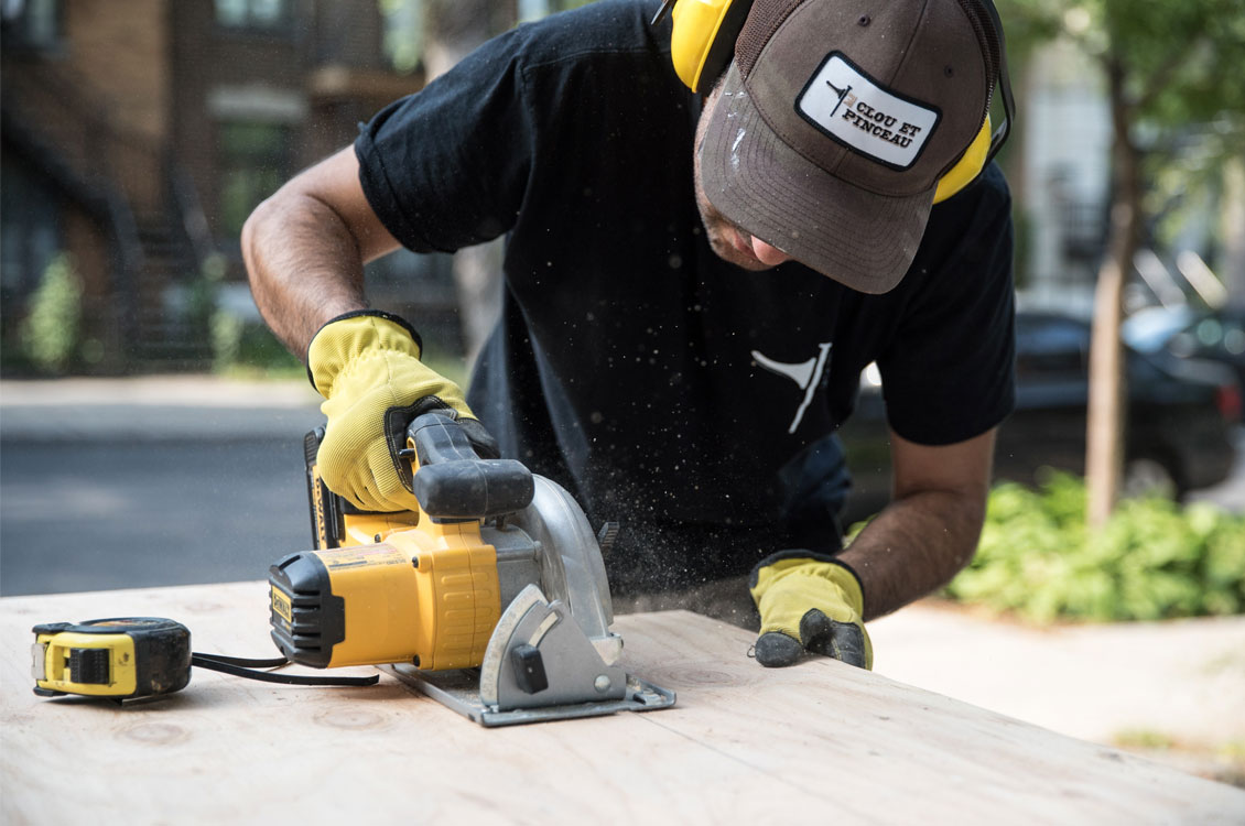 Montreal handyman using electric saw to cut wood