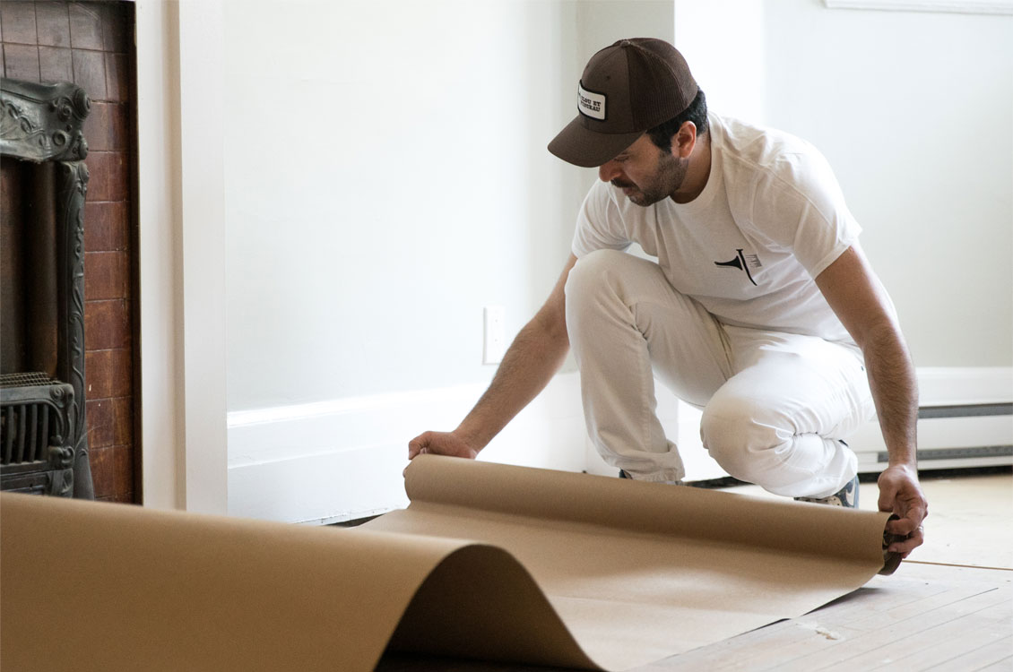 Peintre à Montréal protège le plancher en préparation pour peinture